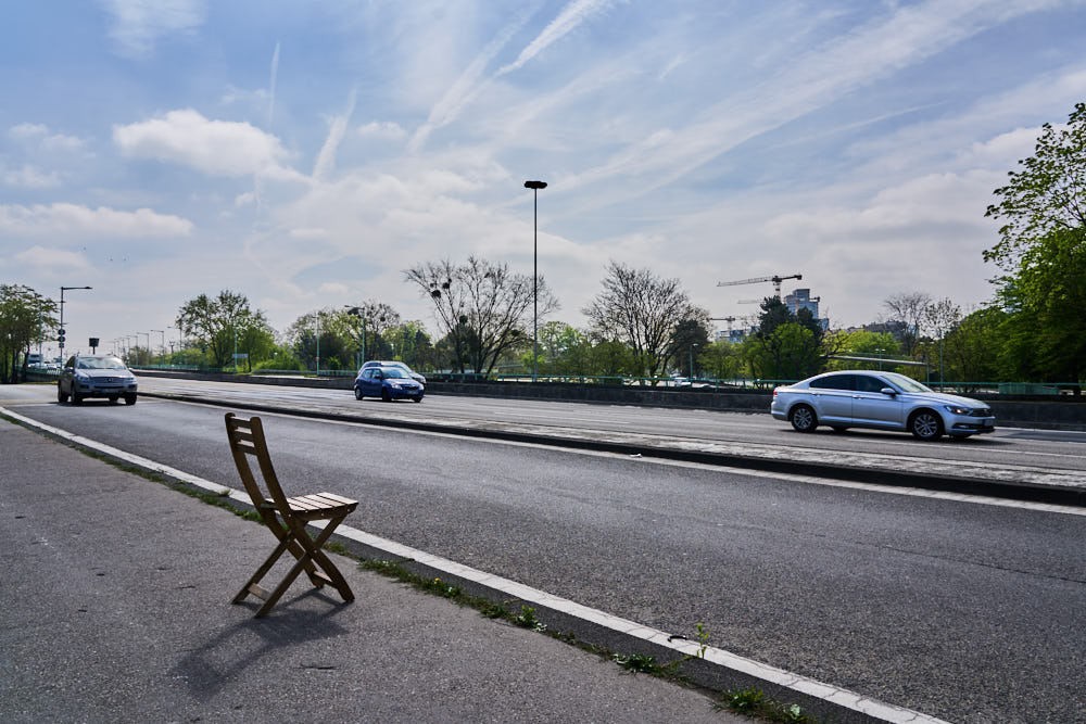 Cars passing by an empty chair